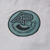 Close view of round Albino and Preto DCDT Give Life Meaning badge on gray kids gi