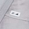 Close view of small Albino and Preto DCDT patch on gray kids gi jacket