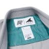 Inner label detail on gray Albino and Preto DCDT GLM kids gi jacket with seafoam lining