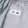 Close view of small Albino and Preto DCDT woven patch on gray kids gi pants