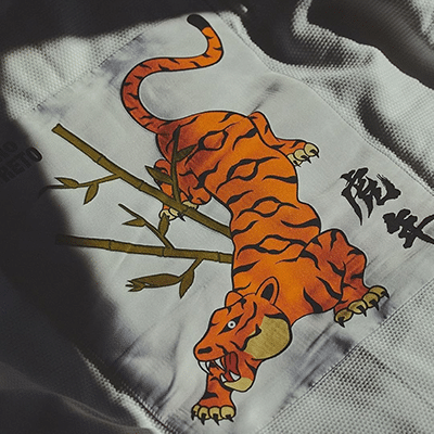 Albino and Preto Batch 110 Year of the Tiger white gi with tiger bamboo artwork patch